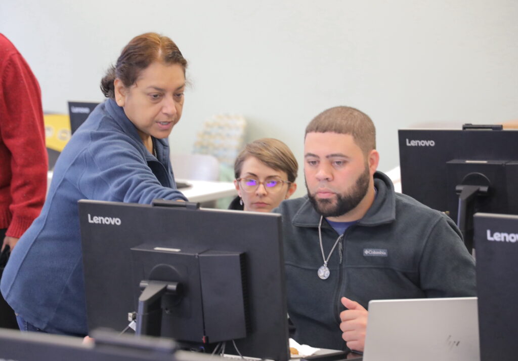 Trainer pointing to computer screen of trainee