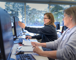 Trainees discussing while working through activity on computers