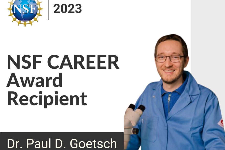 2023 NSF CAREER Award Recipient Dr. Paul D. Goetsch wearing a lab jacket and standing behind a microscope