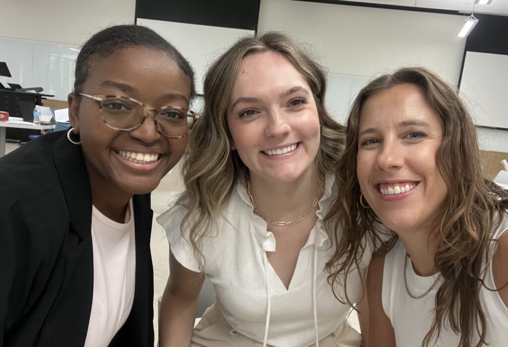 Faculty member Lindsey Long posing for a selfie with two student presenters